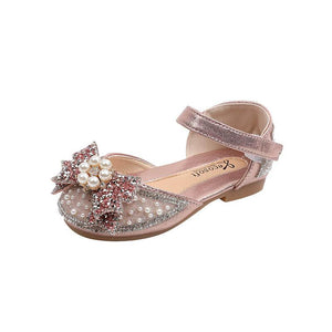 Pink baby shoe with pearl and glitter bow embellishments, ankle strap, and soft sole