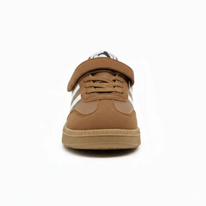 Front view of classic brown and white kids sneakers with laces and velcro strap on white background