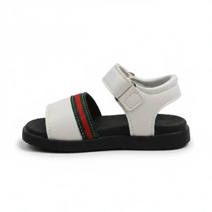 White kids sandals with black sole and green-red-green striped strap over toes