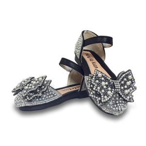 Black baby shoes with ankle straps adorned with pearl and rhinestone-studded princess bow