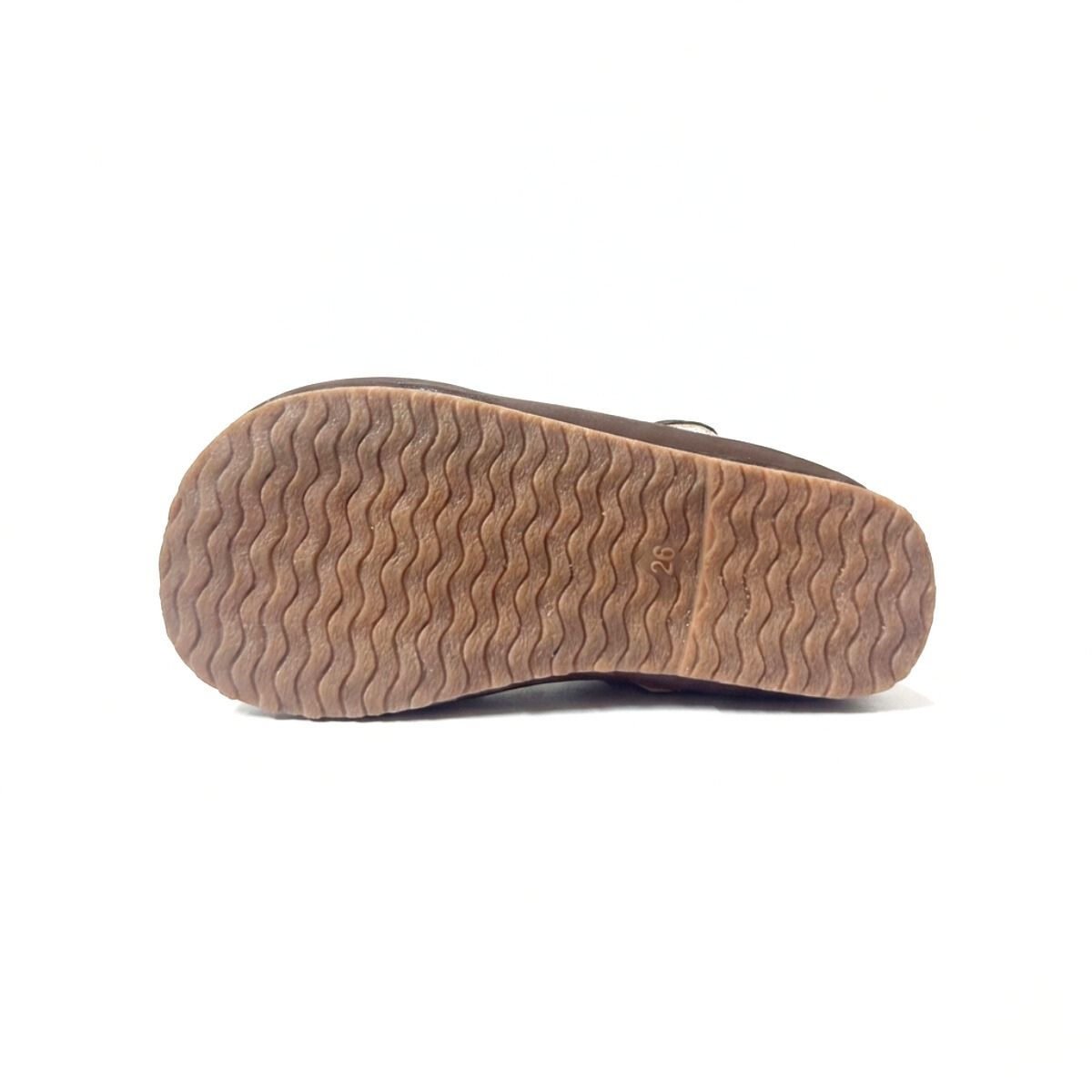 Brown sole of Mary Jane shoe with wavy tread pattern on white background