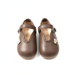 Brown Mary Jane shoes for kids with floral strap detail on white background