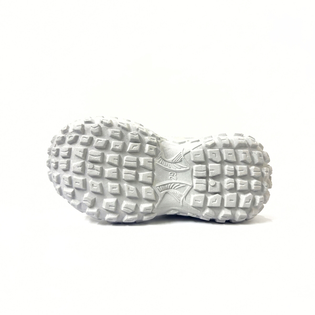 White textured sole of a kids slip-on shoe with geometric tread pattern
