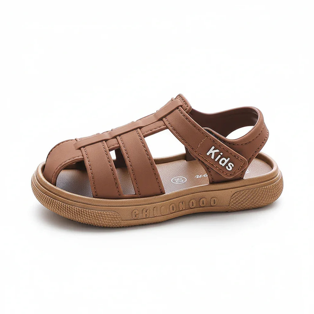 Brown kids summer slide sandal with adjustable strap and textured sole on white background