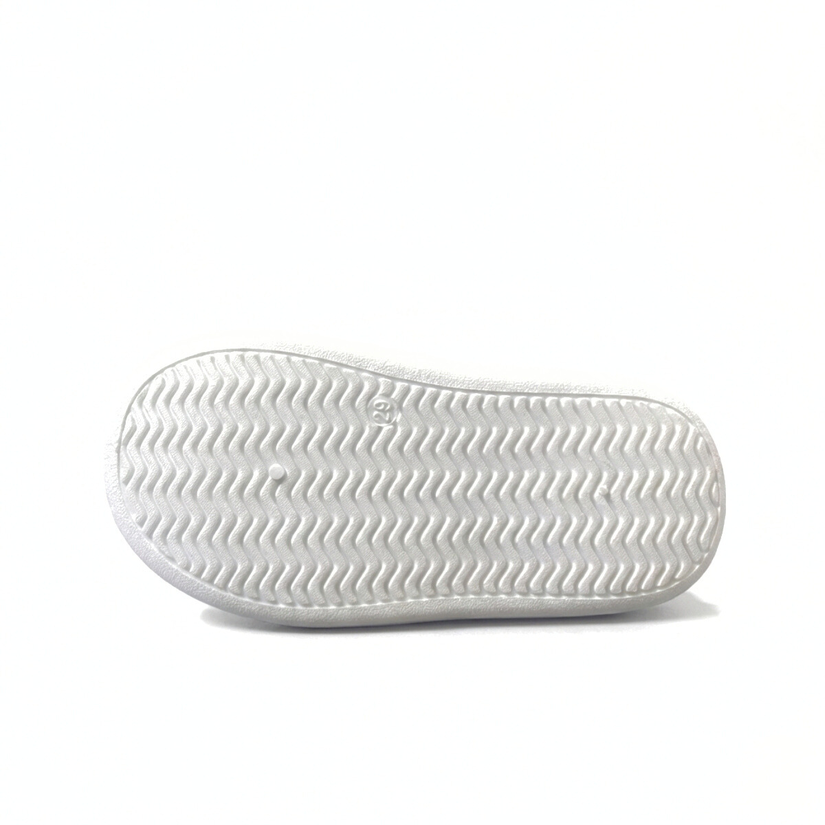 White rubber sole of a mid-top children's sneaker with wavy tread pattern on white background