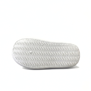 White rubber sole of a mid-top children's sneaker with wavy tread pattern on white background