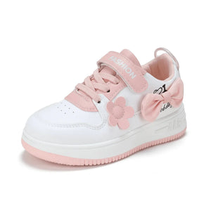 White and pink baby sneaker with flower and bow decoration and Velcro strap labeled Fashion